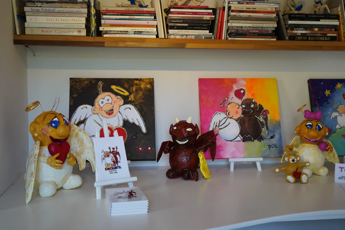 Bunte Gipsfiguren und Bilder stehen aufgereiht nebeneinander.